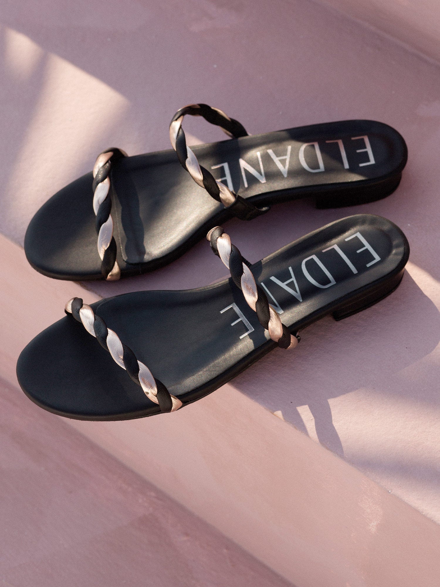 Flat leather sandals in black & rose gold